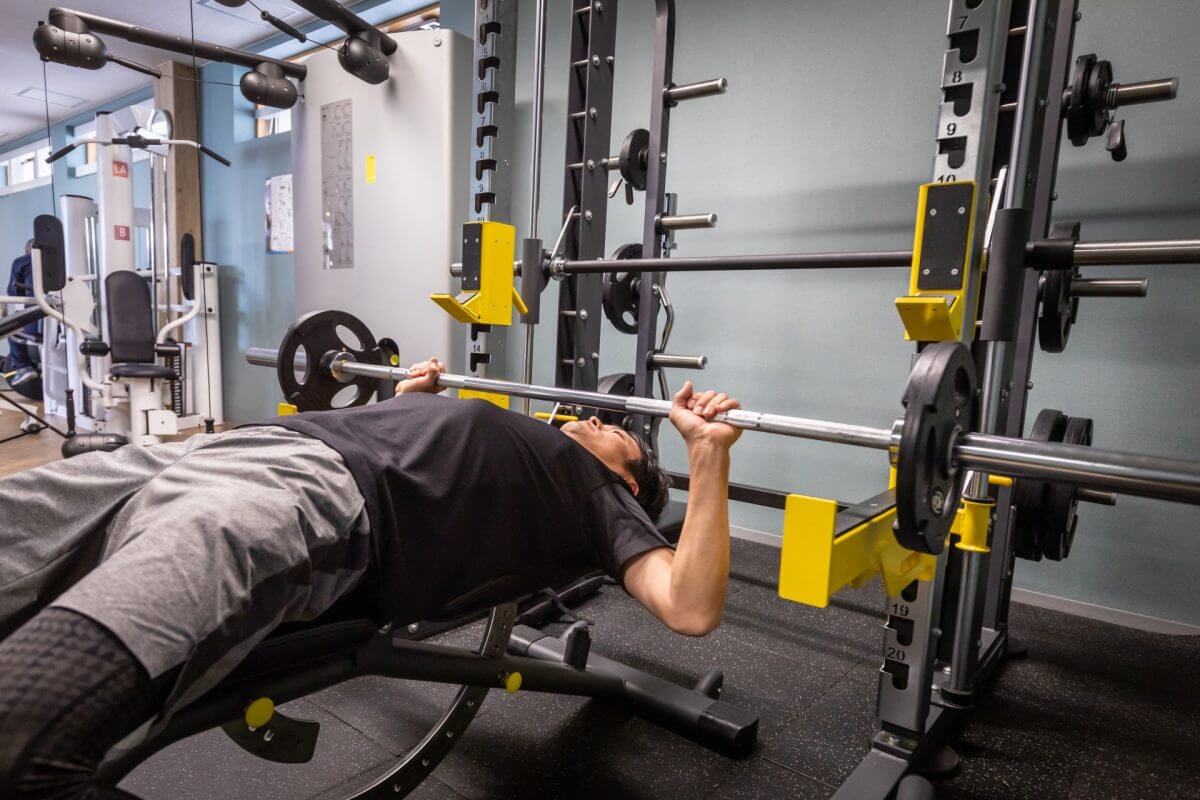 ジムの器具でトレーニングに励む男性