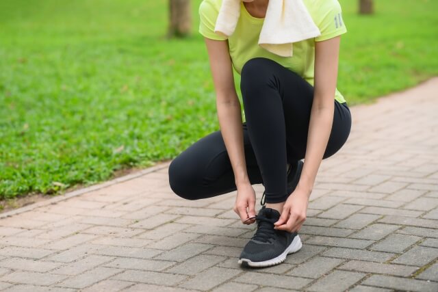 公園で靴紐を結ぶ女性