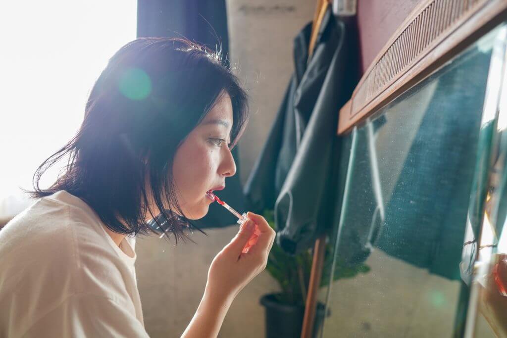 家でメイクをする女性