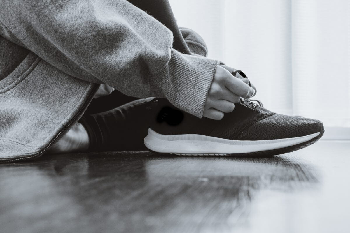 スニーカーの紐を結ぶ人