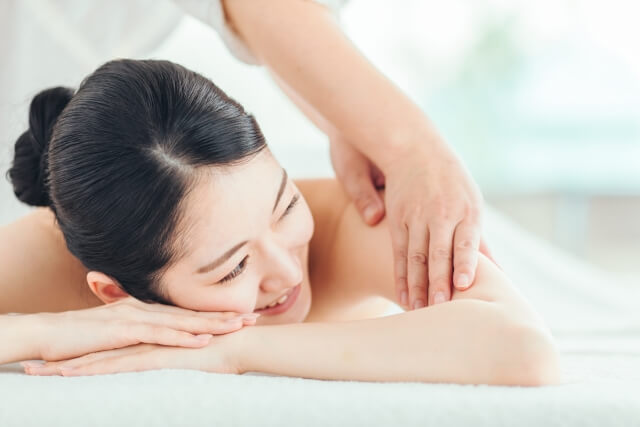 エステをする女性とエステティシャン（腕・肩）
