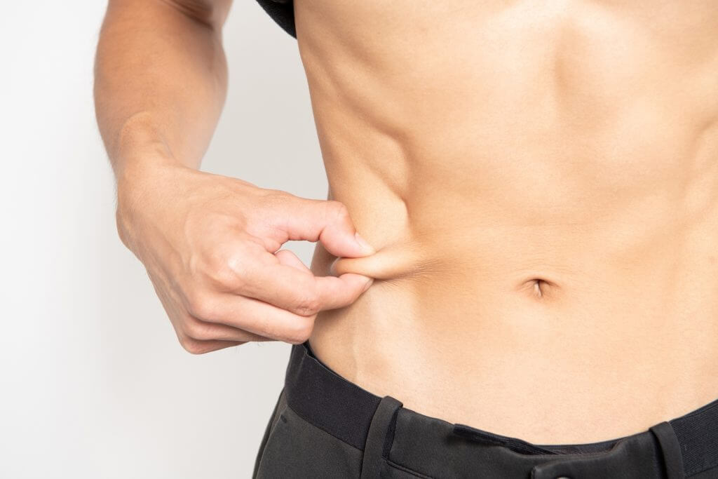 お腹の脂肪をつまむ男性