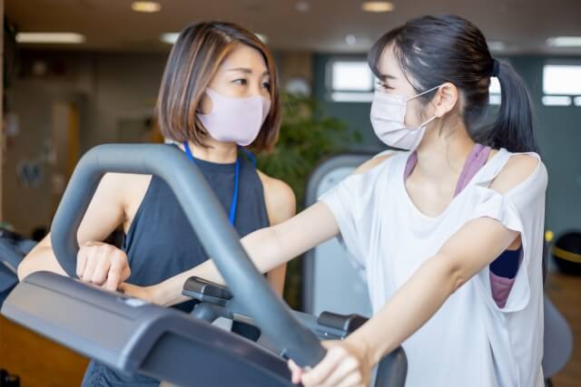 スポーツジムで指導を受ける女性
