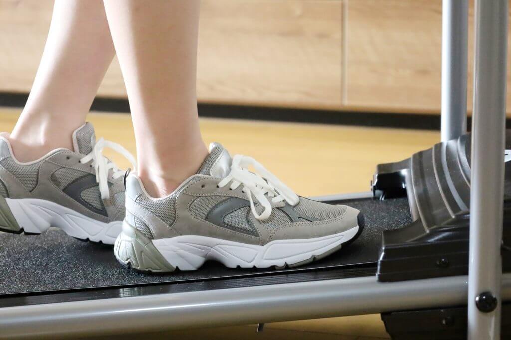 トレッドミルでトレーニングシューズを履いた人