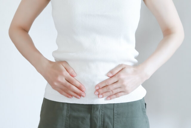 お腹を抑えた女性