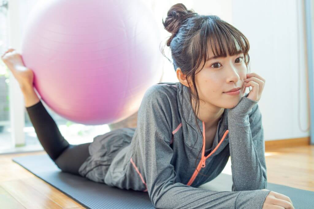 バランスボールで自宅でトレーニングをする女性