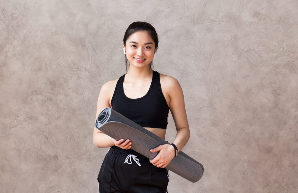 ヨガマットを持つ女性