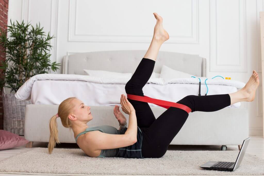 レジスタンスバンドを使って自宅でトレーニングをする女性