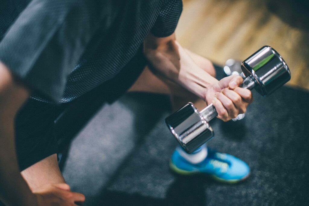 ダンベルで筋トレをする男性