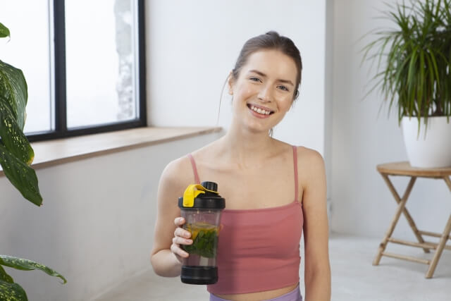 ヘルシードリンクを持つ笑顔女性