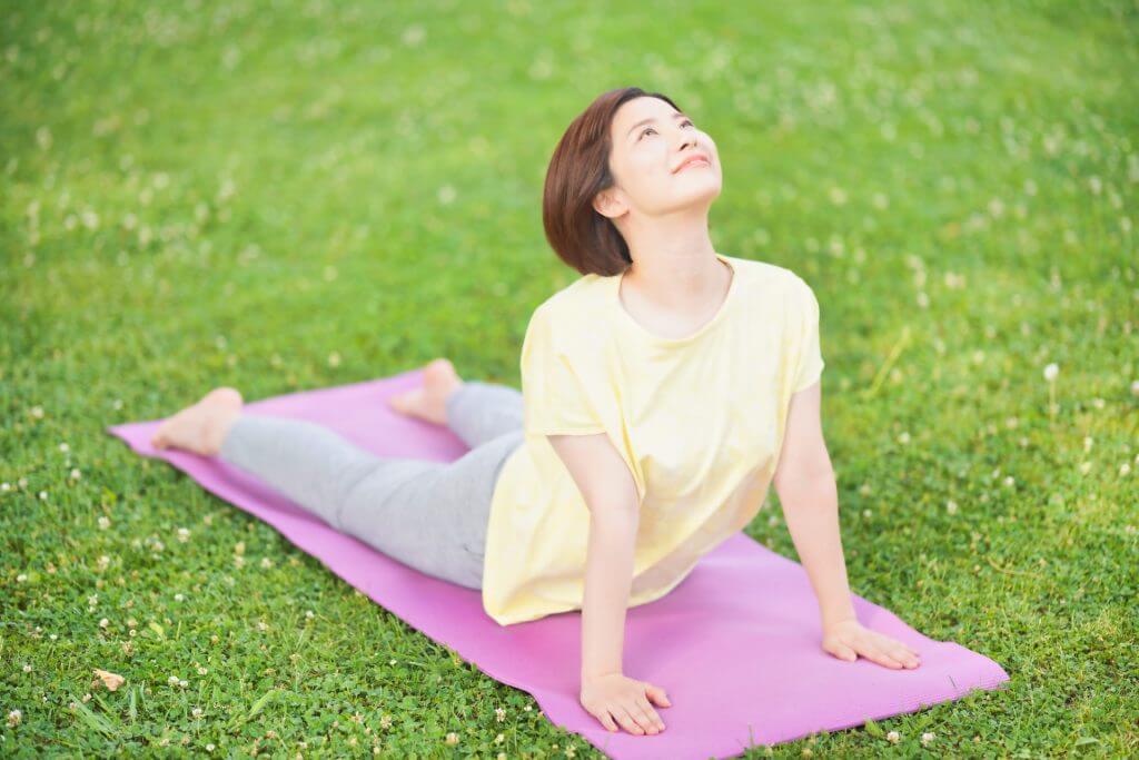 芝生でヨガをする女性