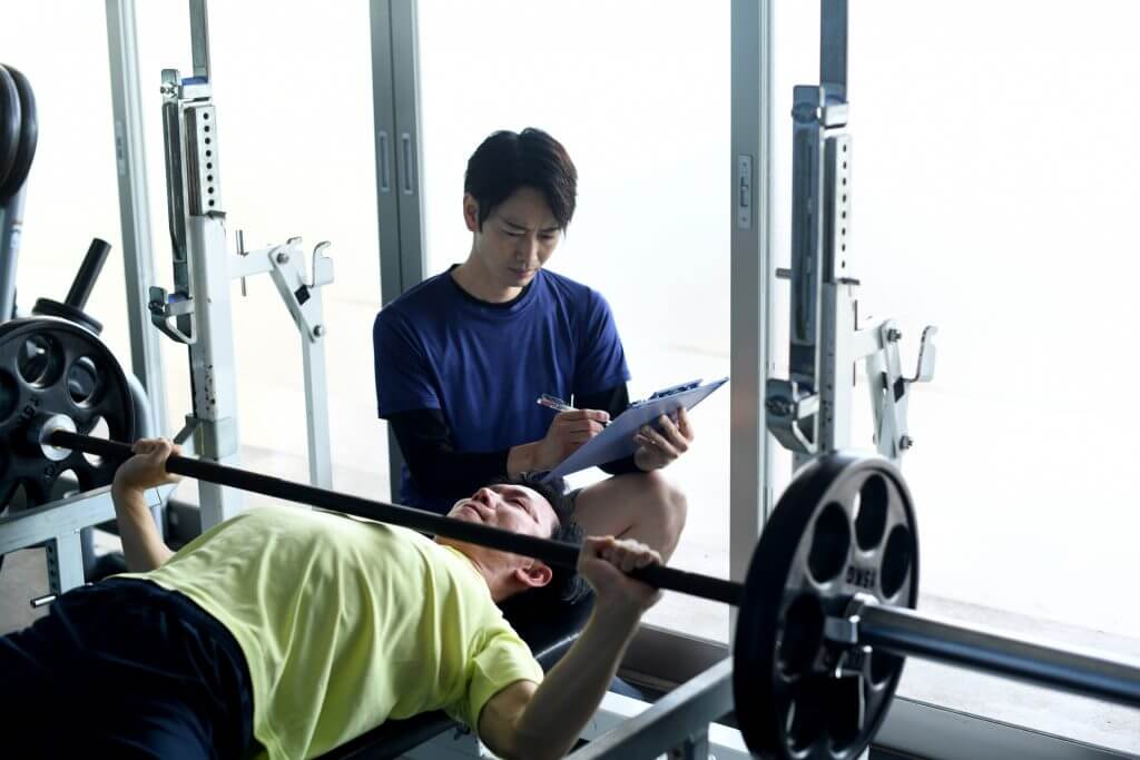 パーソナルジムでトレーニングをする男性