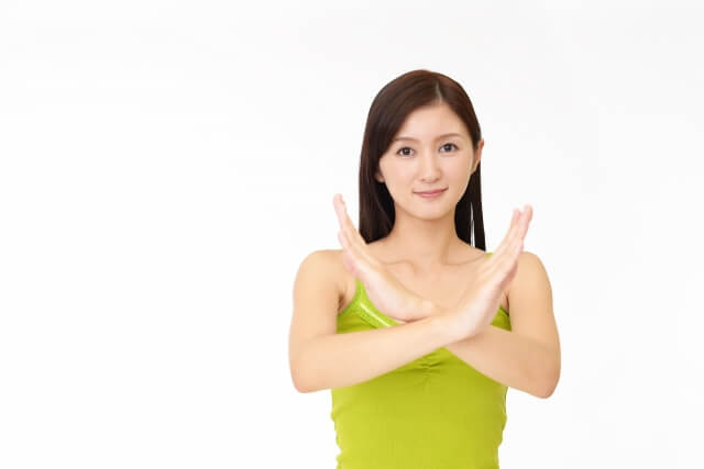 禁止のジェスチャーをする女性