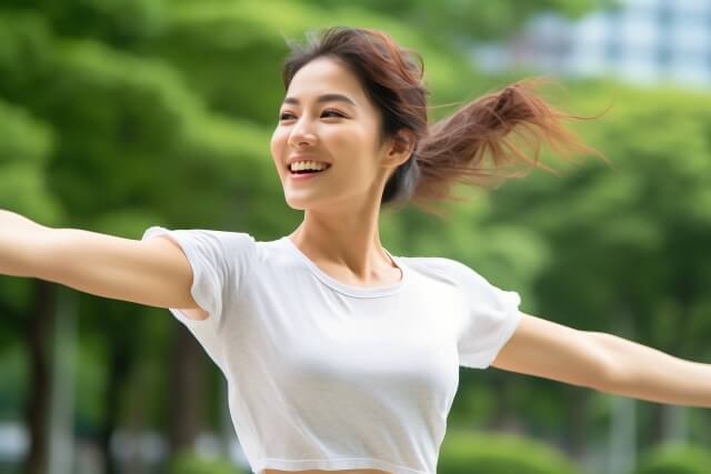 休日に公園でヨガをする日本人の若い女性