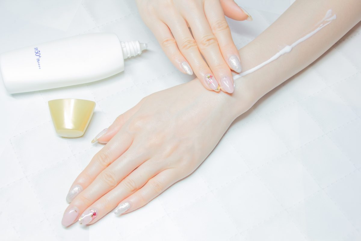 日焼け止めを塗る女性の手