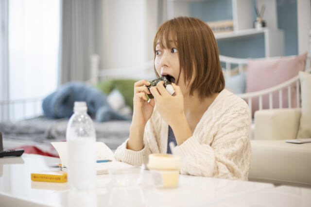 大きく口を開けて食べる女性