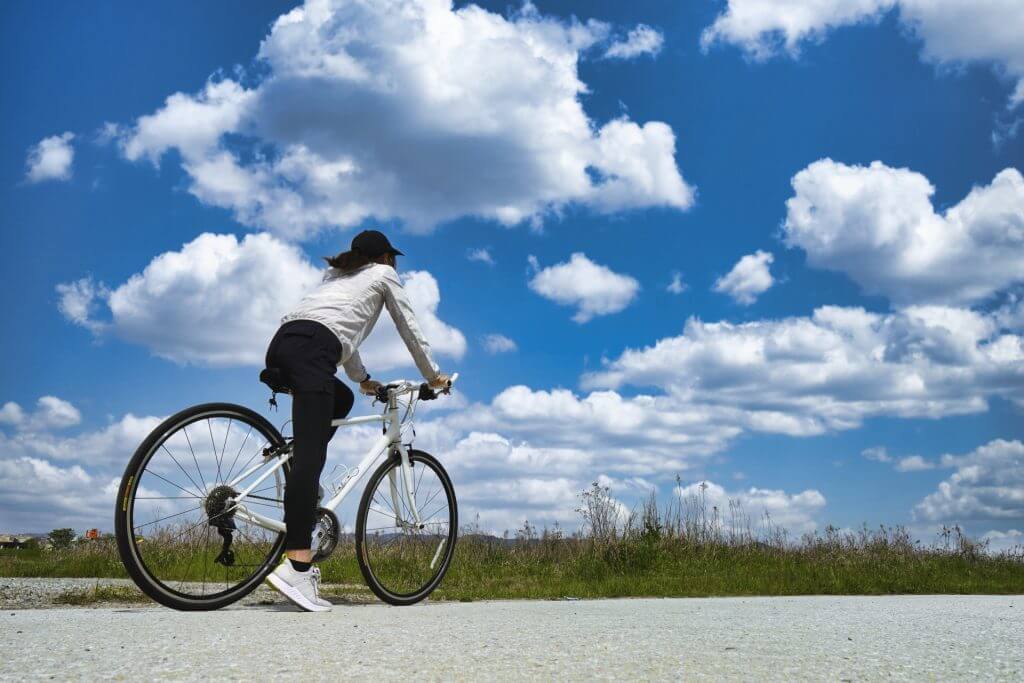 晴天の下サイクリングをする女性